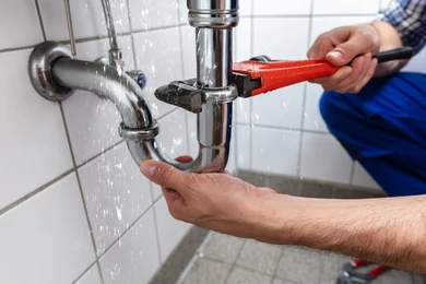 stock image of a plumber fixing a pipe